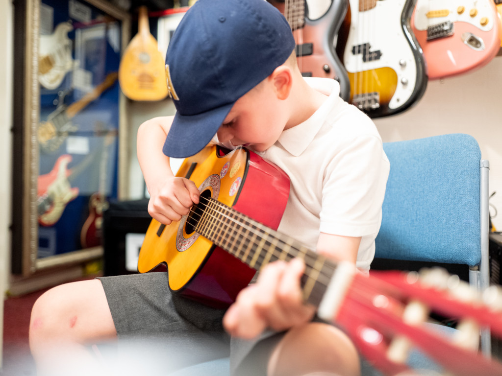 Child having a lesson on classical guitar.